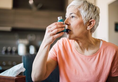 Woman using inhaler for respiratory condition COPD