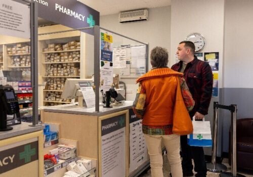 two patients at a pharmacy counter