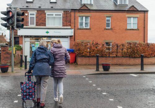 two people walking to a pharmacy