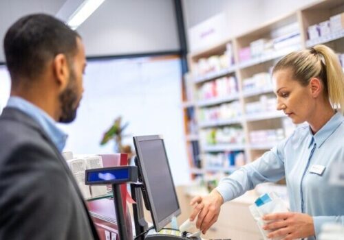 pharmacist talking to patient over the counter