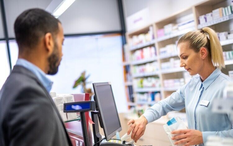 pharmacist talking to patient over the counter
