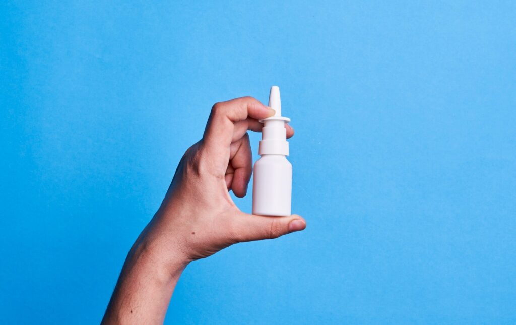white nasal spray on blue background