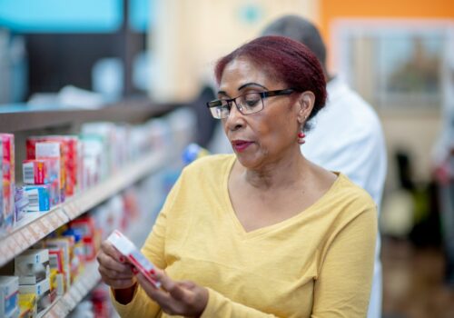woman looking at meds in pharmacy