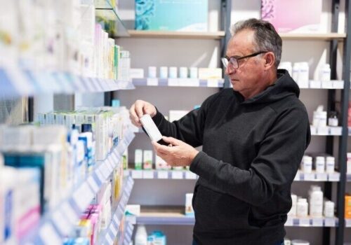 man looking at medicines in a pharmacy