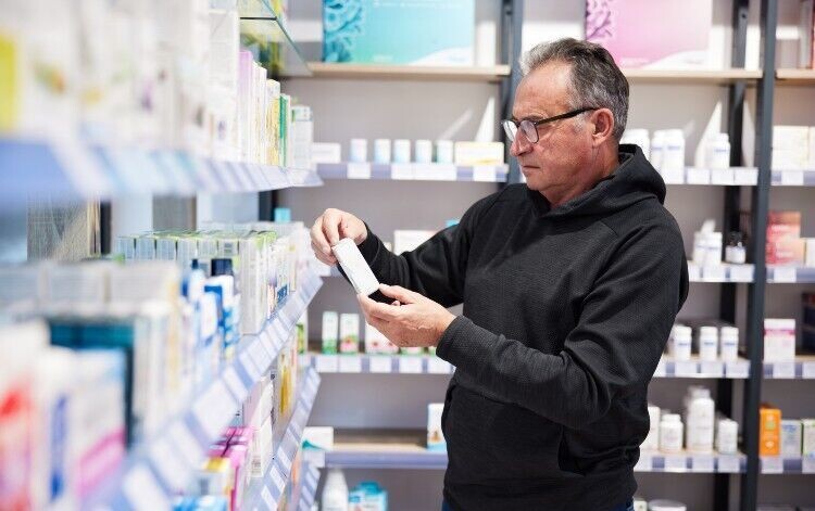 man looking at medicines in a pharmacy