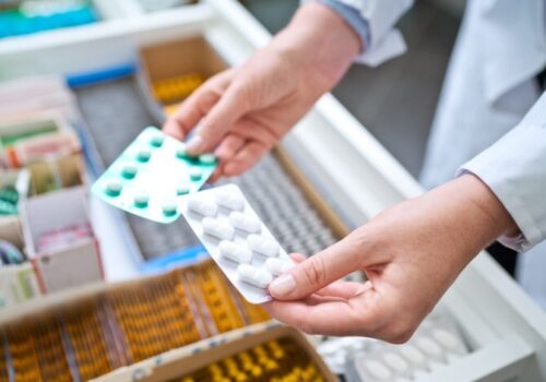 Someone's hands holding two pill packets