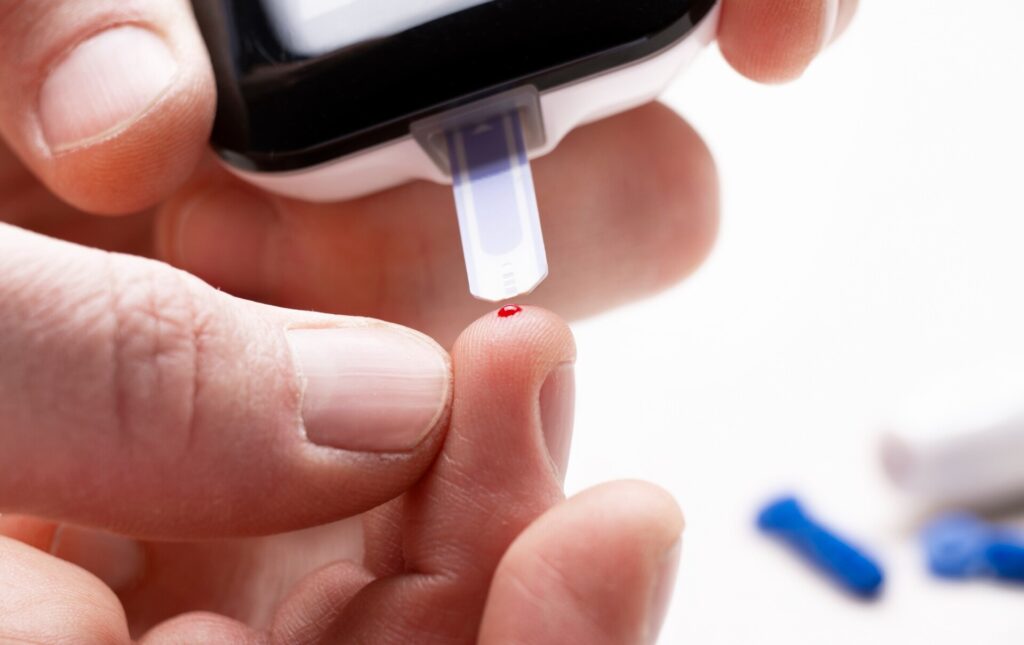person testing blood sugar levels with device