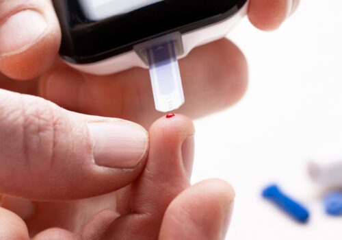 person testing blood sugar levels with device