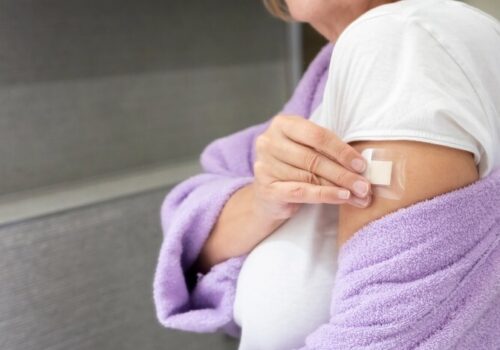 woman putting hrt patch on her arm