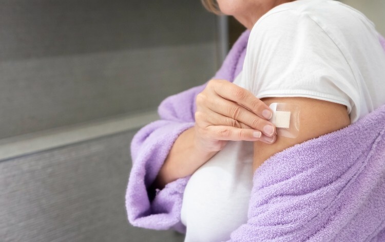 woman putting hrt patch on her arm