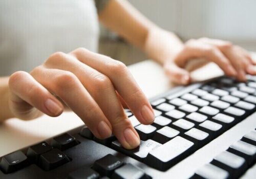 person typing on keyboard, filling in survey