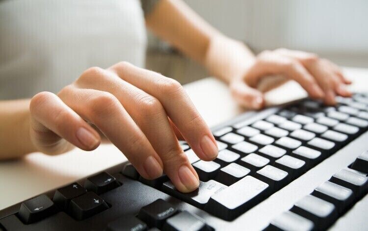 person typing on keyboard, filling in survey