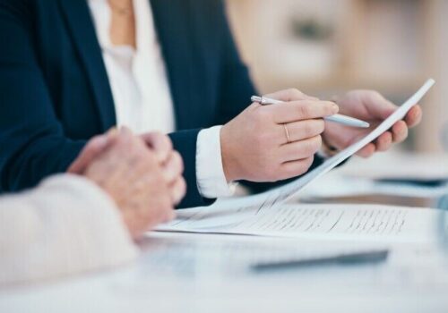people sat around a table looking at paperwork