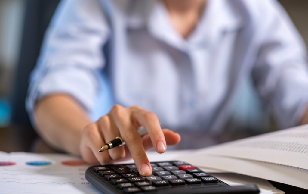 pharmacist using calculator sat at a desk gp practice