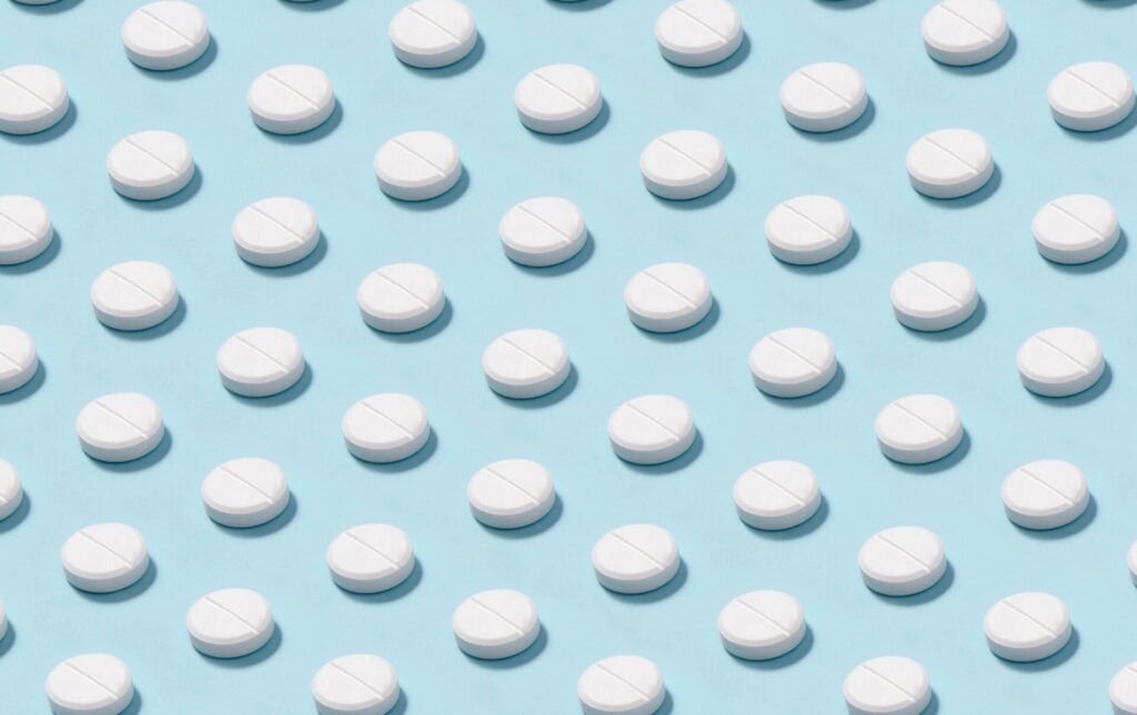 white tablets pills medicines drug on blue background