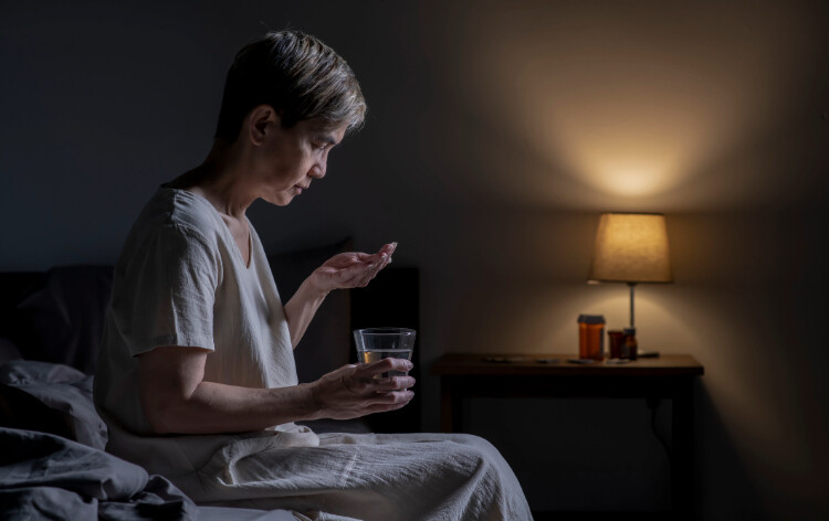 Woman taking pills in the dark