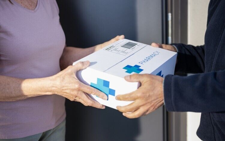patient being passed a pharmacy package