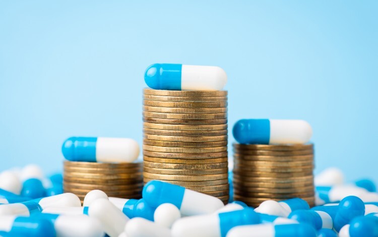 Coins stacked up with pills balanced on top