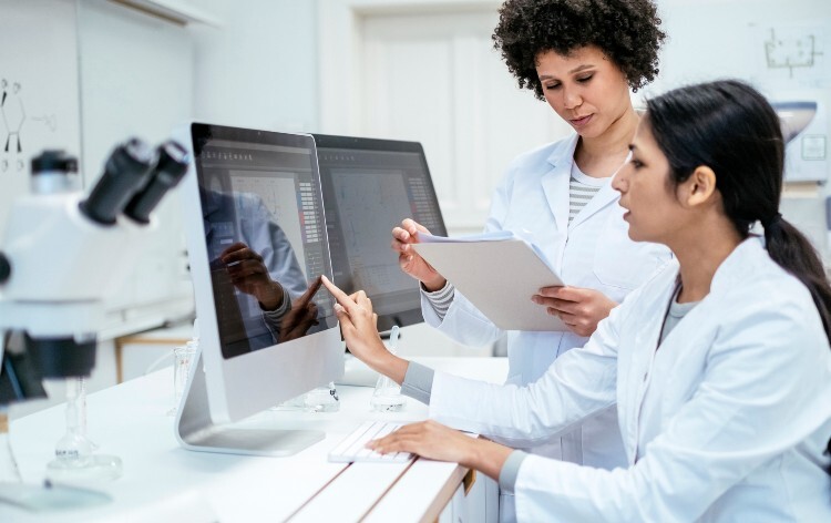 scientists looking at data on screen in clinical trial
