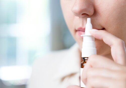 Person using a nasal decongestant spray