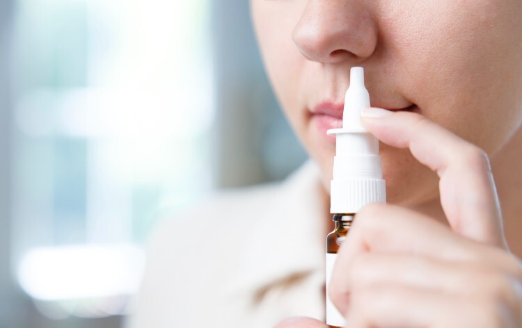 Person using a nasal decongestant spray