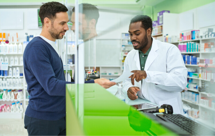 Pharmacist speaking with a customer in a pharmacy.