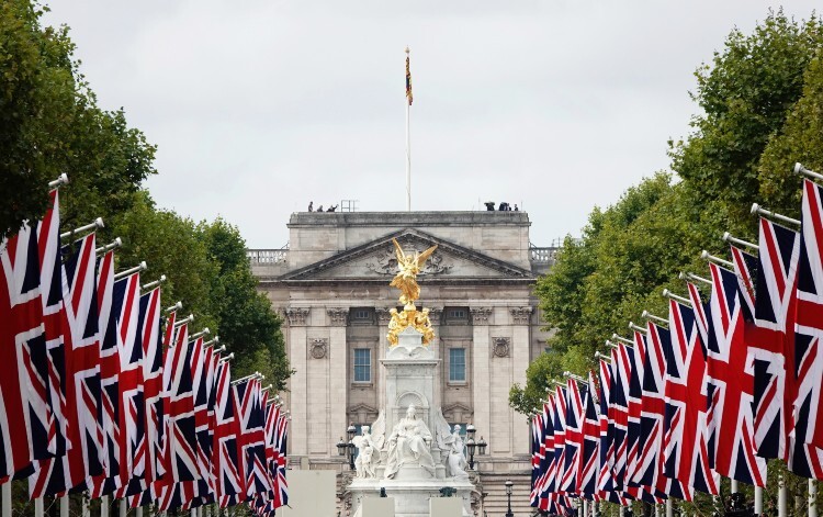 The front of Buckingham Palace with union jack flags