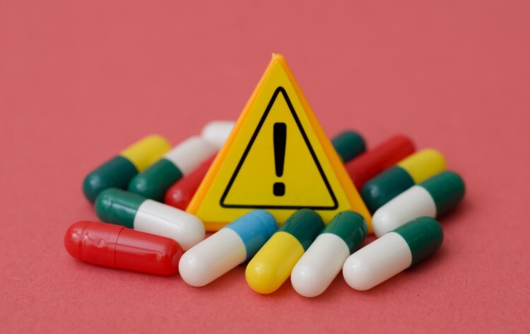 Yellow Warning Exclamation Sign Surrounded by Medical Capsules