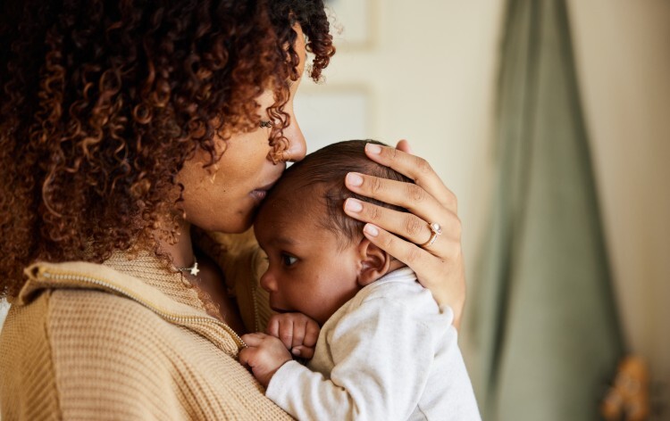 Mother kissing with her baby boy in her arms