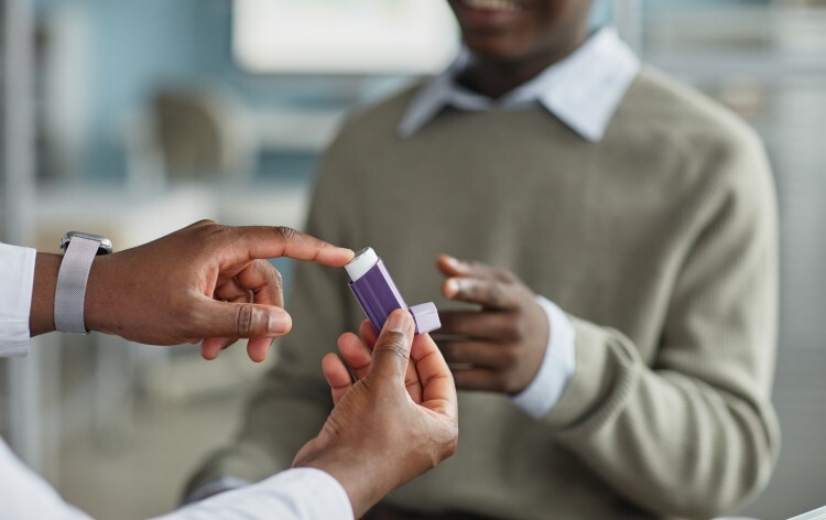 Young Adult Black Man Receiving Asthma Inhaler from Medical Professional