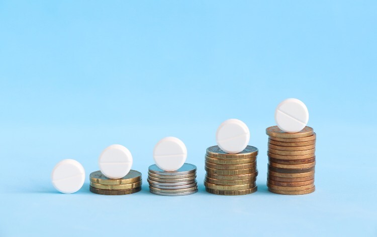 Money increasing with pills balanced on top
