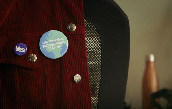 jacket with a pin badge saying Stop the world Scotland wants to get on