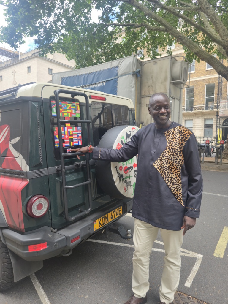 H.E Ambassador Maurice Makoloo, Kenyan High Commissioner to the UK applying the final flag (Union Jack) to Becky's Grenadier outside the Kenyan Embassy, London