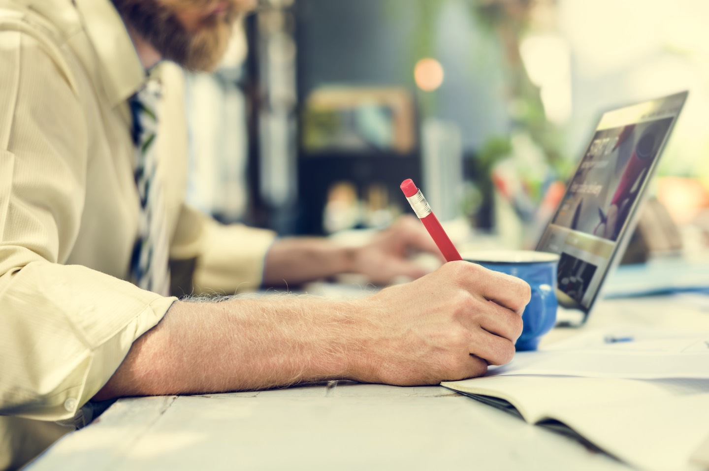 businessman-writing-notebook-working-laptop-PBUL8BD Man writing content strategy