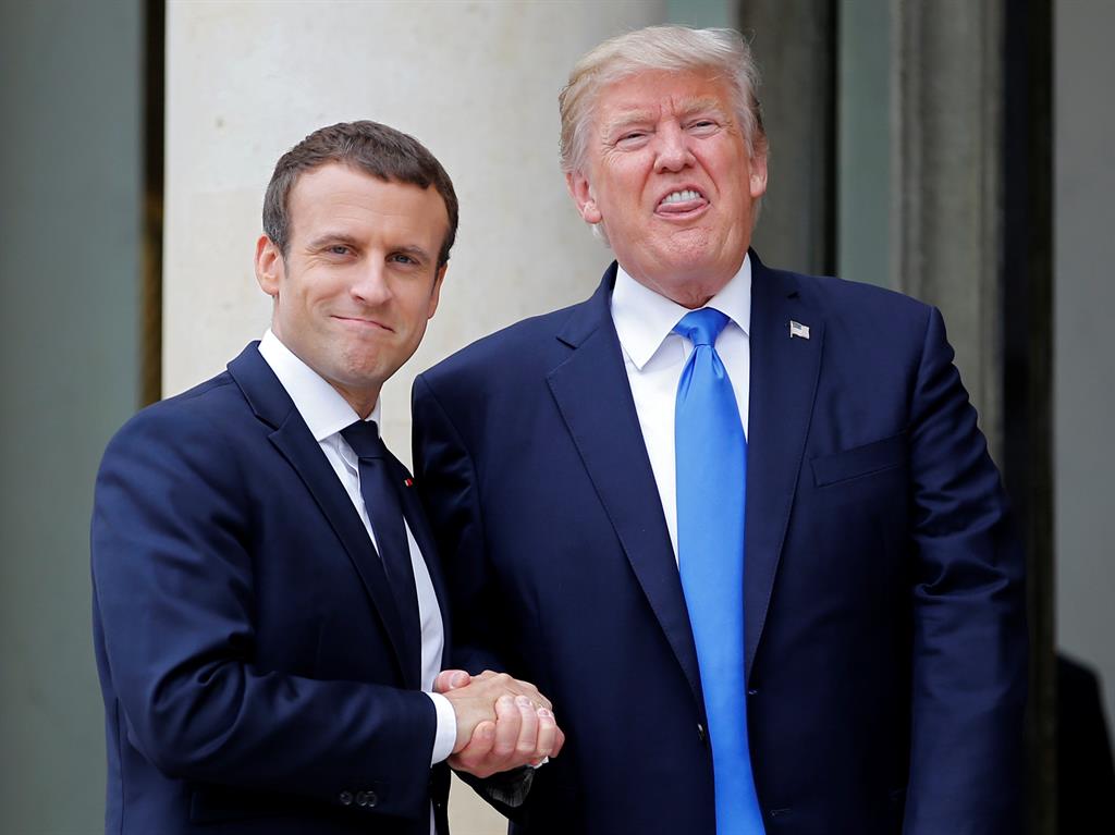 Getting to grips Donald Trump winces as he shakes hands with Emmanuel Macron while his son faces questions