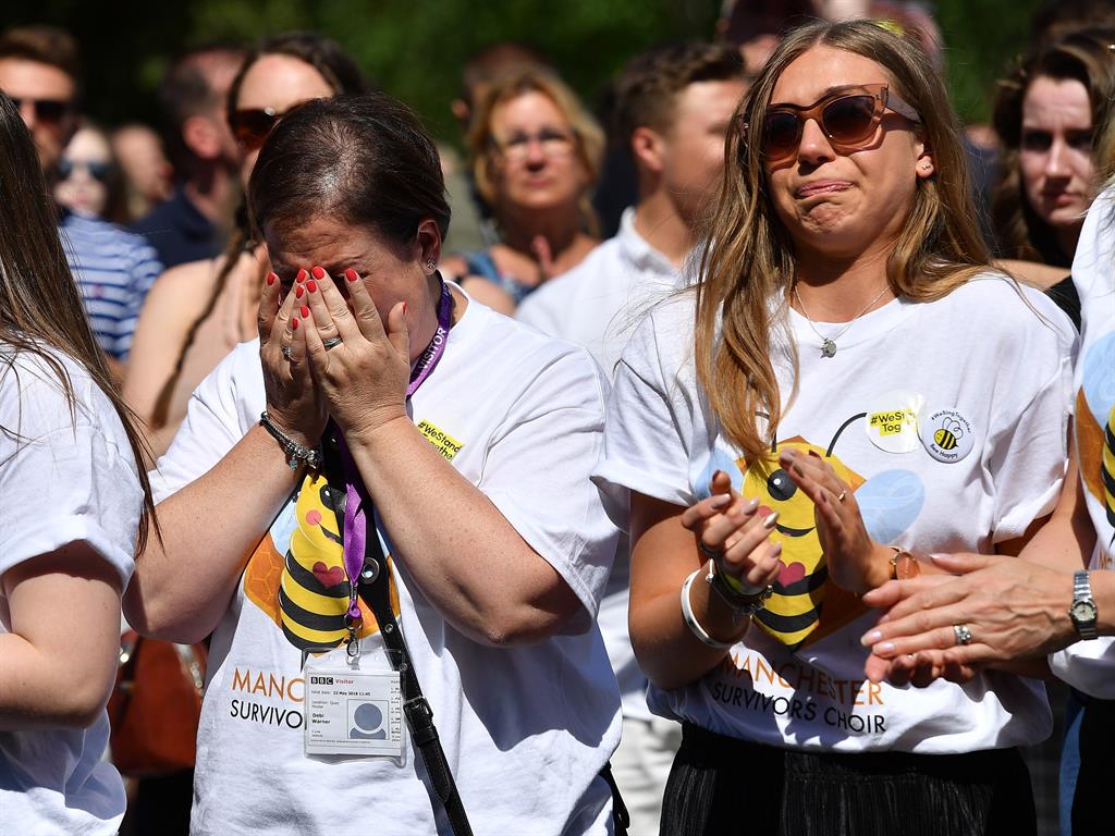 Overcome: People in Manchester observe the minute's silence