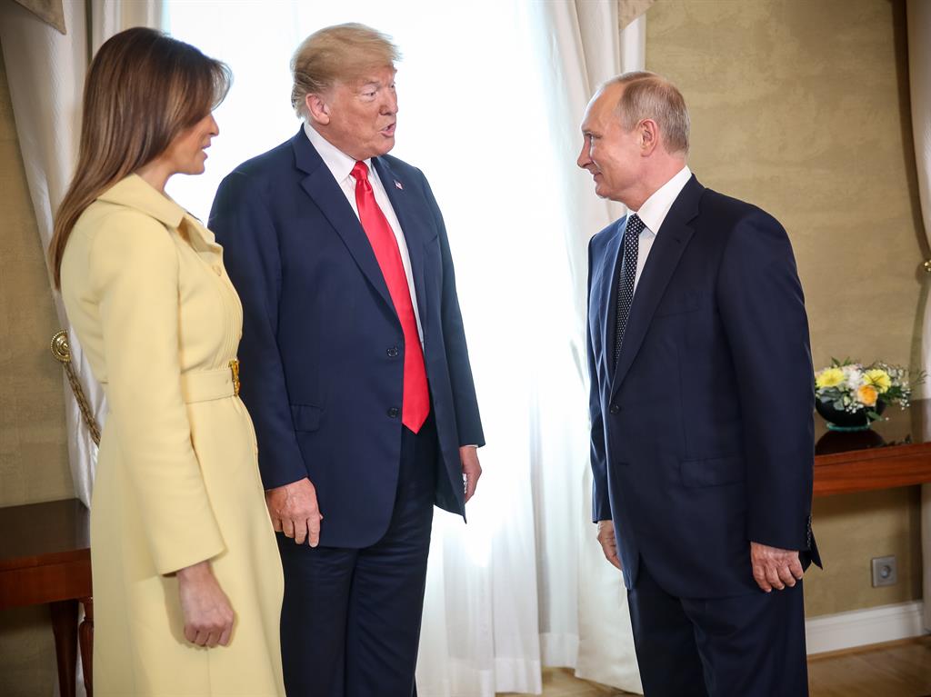 Smiles better: Donald Trump and wife Melania speak with Vladimir Putin PICTURE: EPA