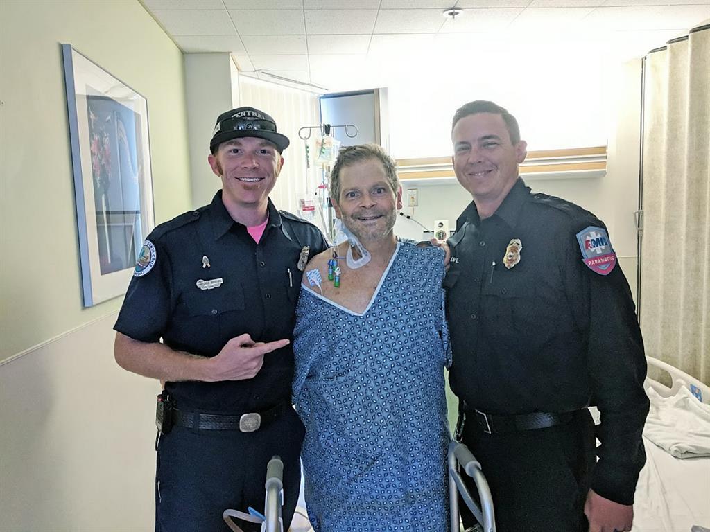 Lucky to be alive: Max Montgomery with paramedics after surgery