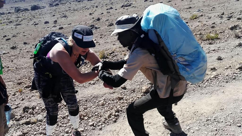 Helping hands: Corinne received much support during her African adventure (also below), which she said got her to the top of the mountain