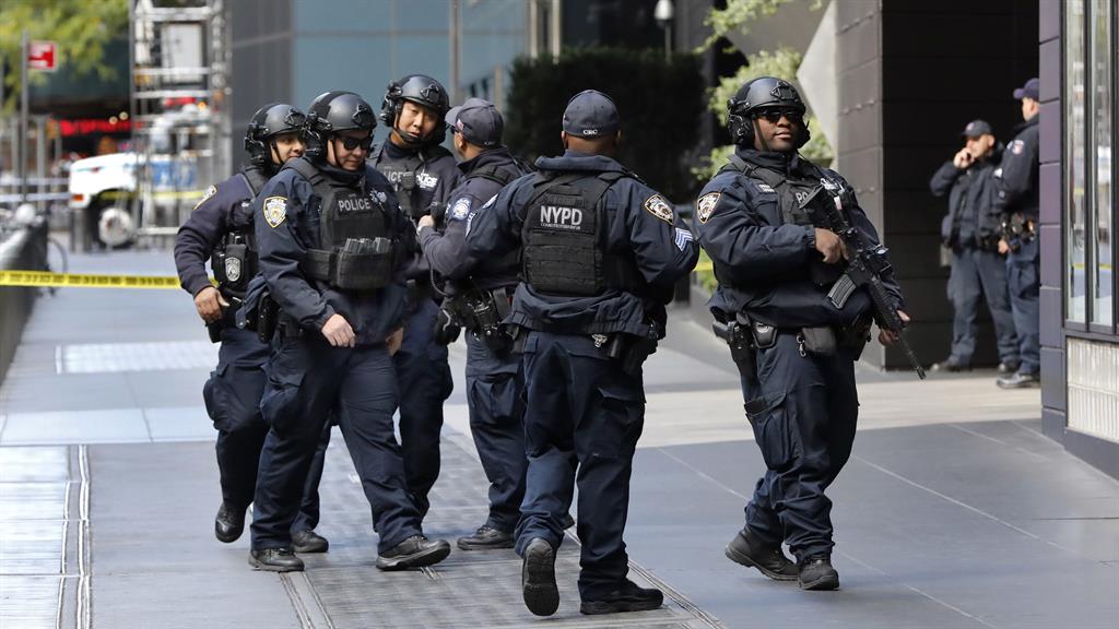 Toxic times: Armed police on the streets of New York after bomb alert at CNN PIC: AP