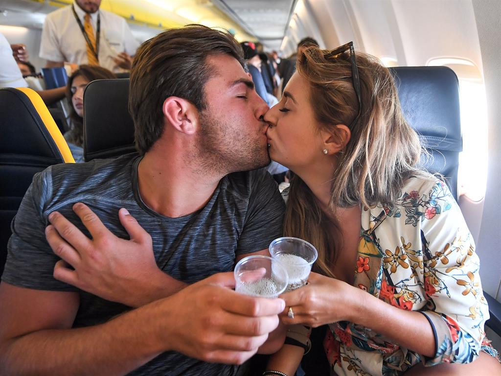 Loved up: Jack and Dani celebrating their win with champagne on the flight home back in July PICTURES: REX