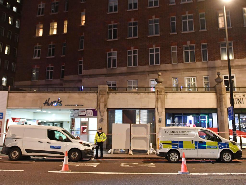 Murder scene: Police guard the entrance to the building in Park Lane PICTURE: PA