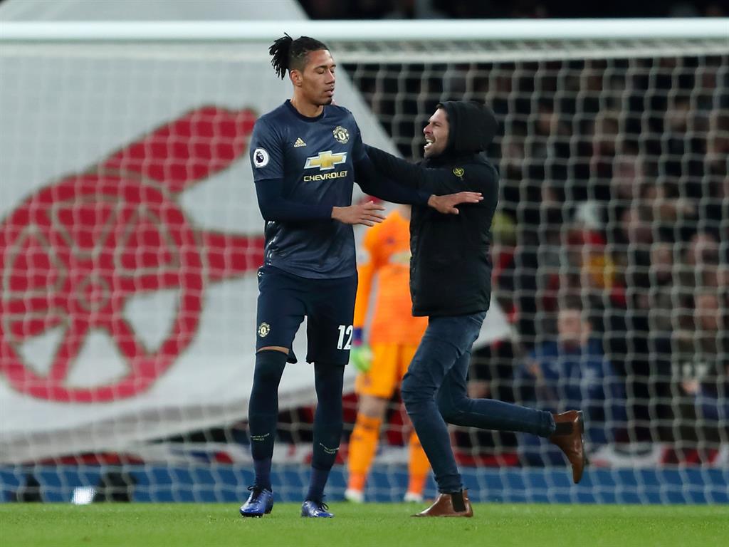 At risk: A fan runs onto the pitch and confronts Man United player Chris Smalling PICTURES: GETTY/SKY SPORTS/REX