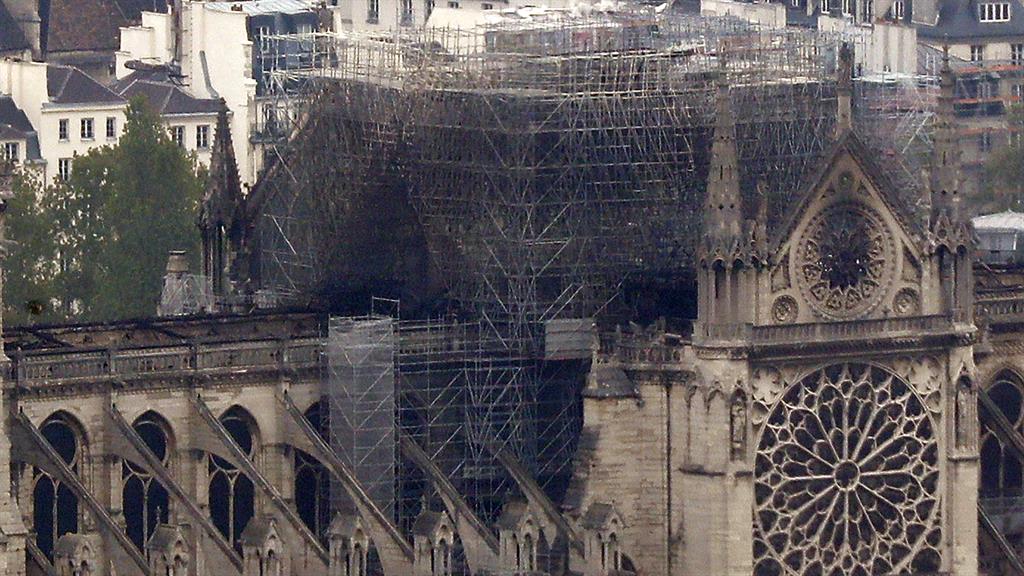 National tragedy: The inferno engulfed Paris's iconic Notre Dame cathedral, claimed its spire and roof, but spared its bell towers, to the left of this picture