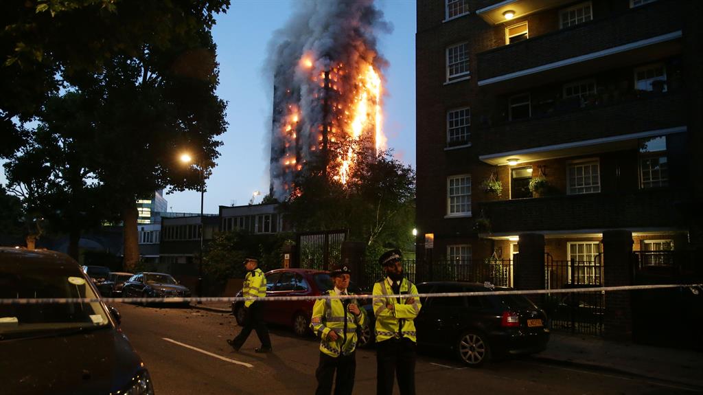 Tragedy: Police oversee a security cordon as fire engulfs Grenfell Tower PICTURE: AFP