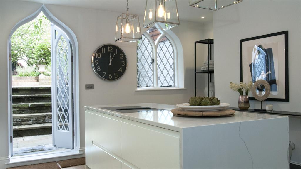 Beyond the fridge: The open-plan kitchen leads out to the garden. Below: The bedroom’s distinctive vaulted roof