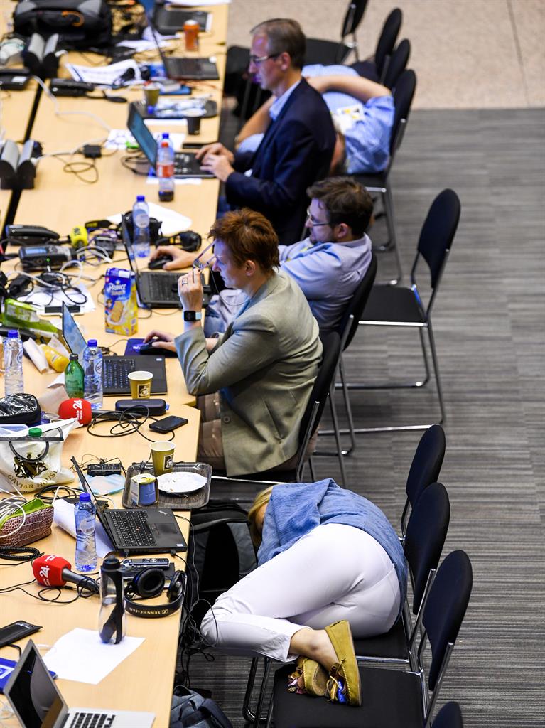 Dream job: Reporter makes a bed out of three chairs after talks went on all night