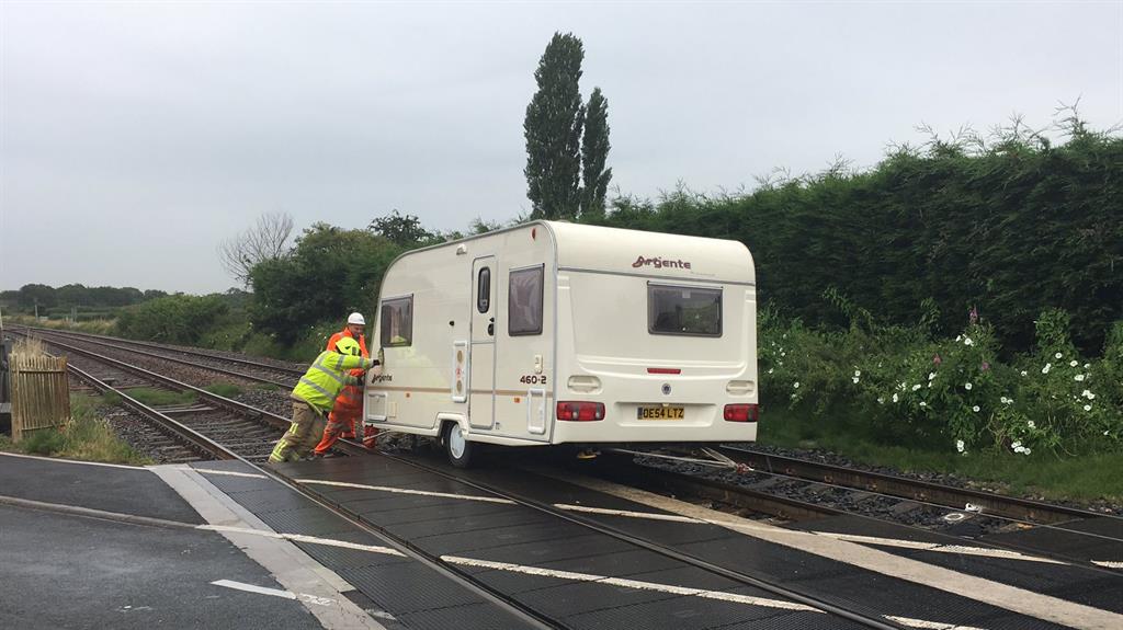 Heave: Emergency crew push the caravan off the line PICTURES: SWNS