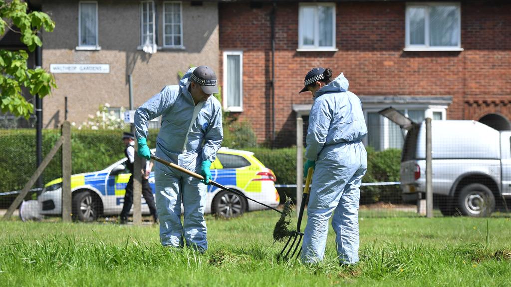 Police search the area surrounding the house PICTURE: PA