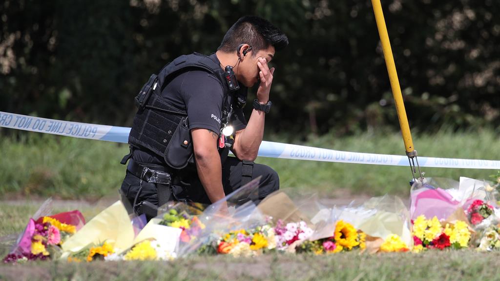 Emotional: A police officer pays his respects at the scene of PC Harper's death PICTURE: PA